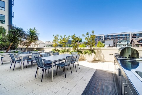 a rooftop patio with tables and chairs and a pool