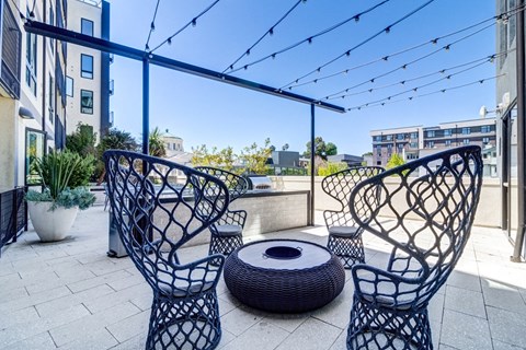 an outdoor patio with chairs and a fire pit