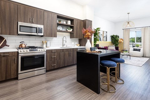 A modern kitchen with dark wood cabinets and a black island.