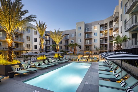 Echo Park Apartments - Alexan Bahay Apartments - Dazzling Lit up Swimming Pool at Night Surrounded by Lounge Seating