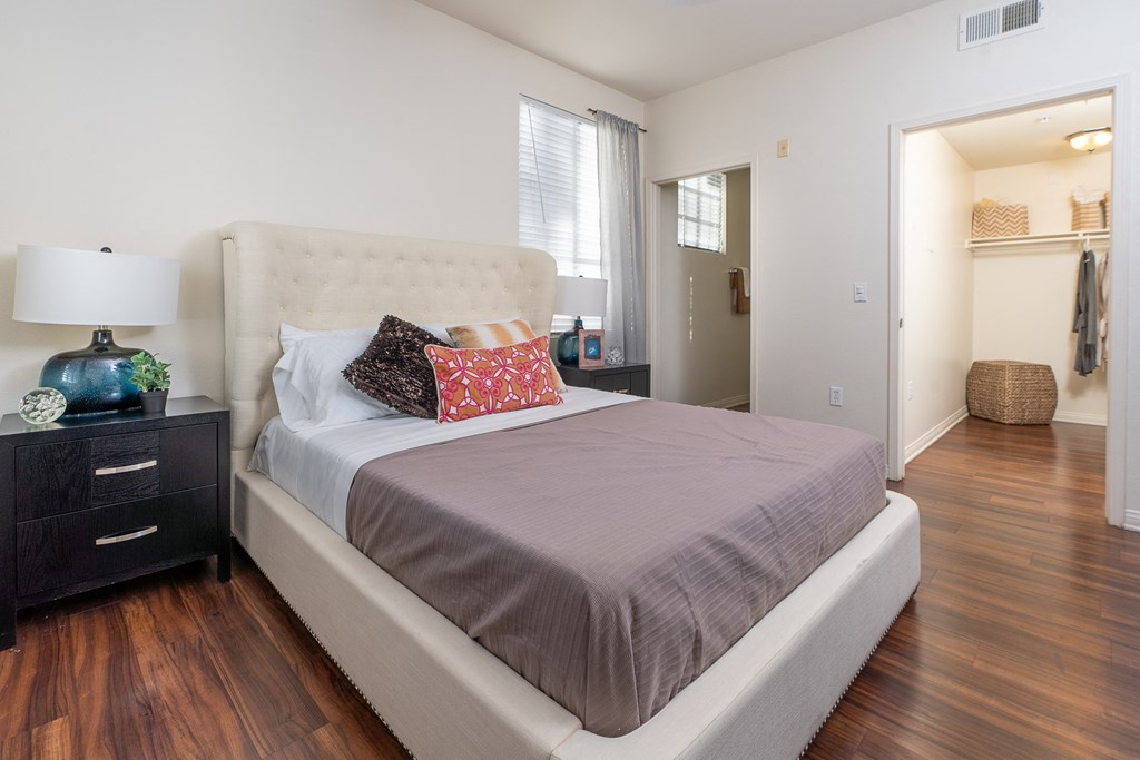 Apartments for Rent in Rancho Cucamonga - Barrington Place - Bedroom with Wood-Style Flooring, Attached Bathroom, Walk-In Closet, Bed, Night Stands Lamps, and Window