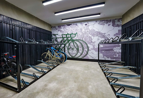 a room filled with bikes and a mural of a city on the wall at NoMa Apartments, Walnut Creek, CA