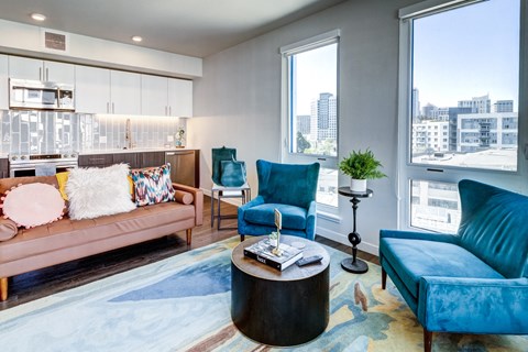 a living room with blue chairs and a pink couch