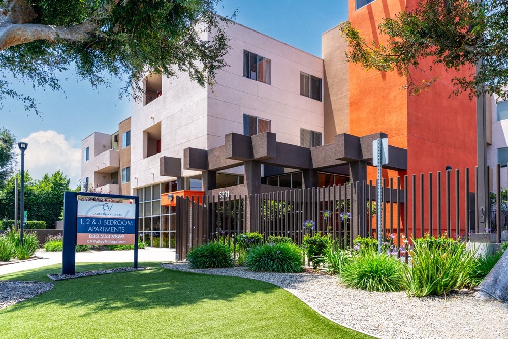 a garden in front of a building with a sign