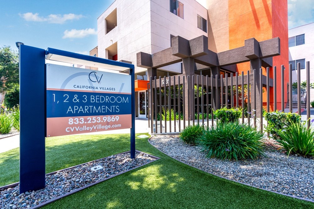 a rendering of a building with a sign in front