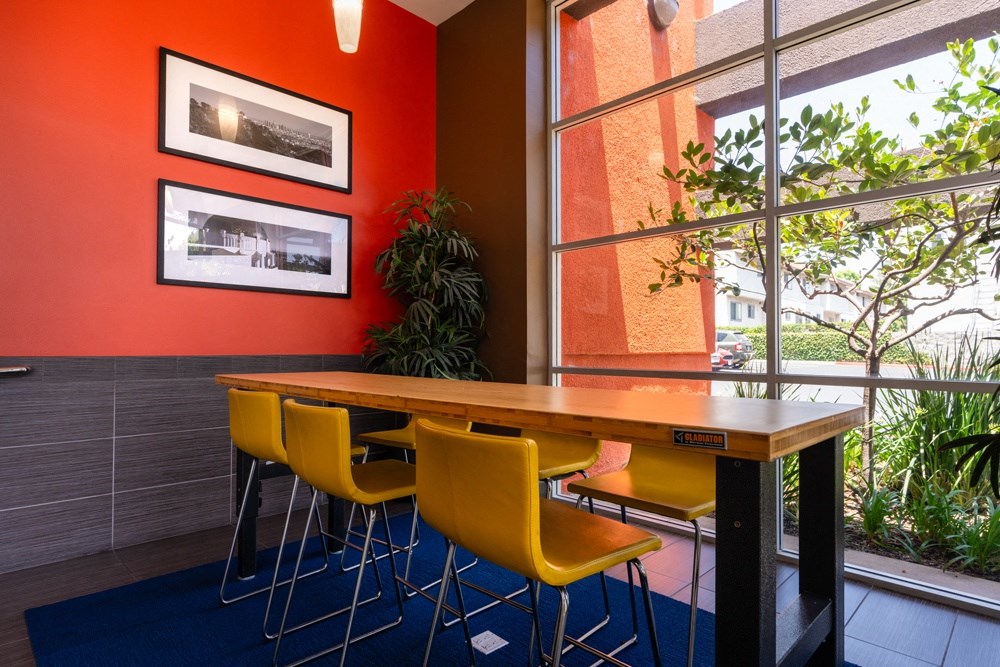 a dining room with yellow chairs and a wooden table
