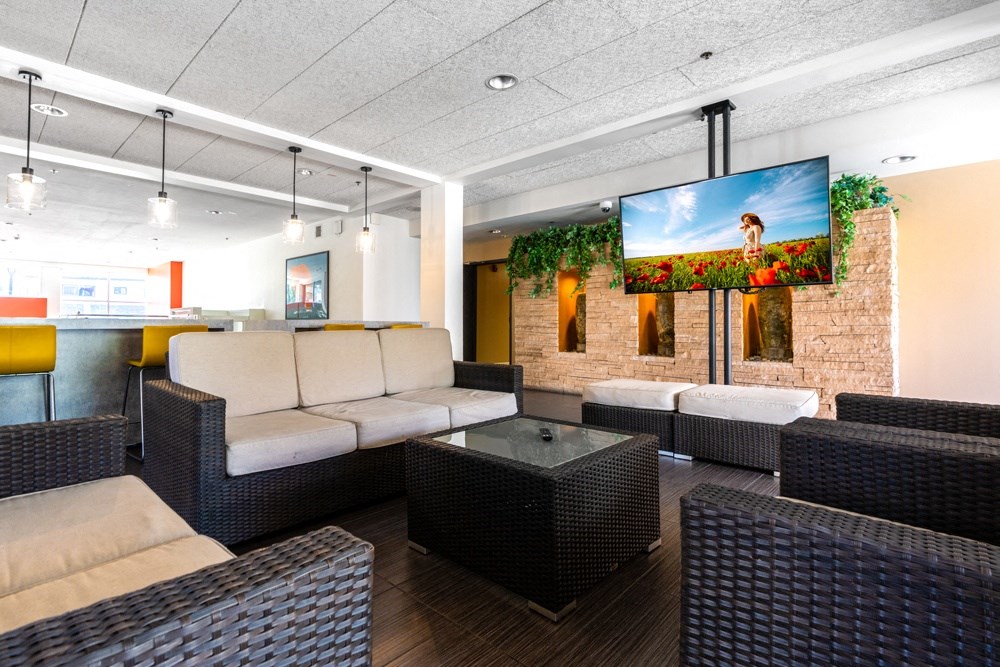 a lobby of a hotel with couches and a television