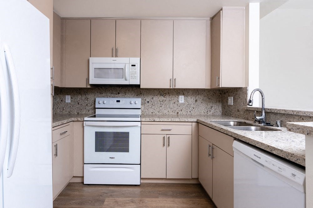 a kitchen with white appliances and granite counter tops