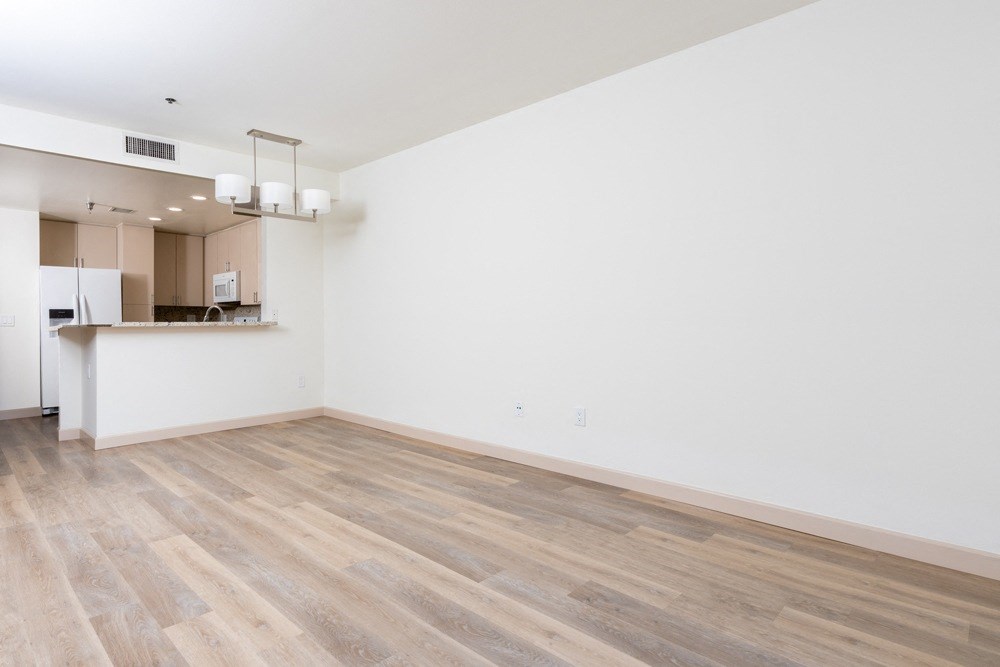 an empty living room with white walls and wood flooring