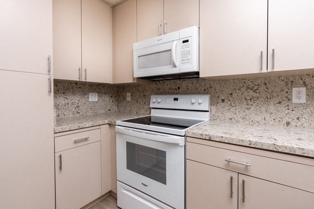 a kitchen with white appliances and granite counter tops