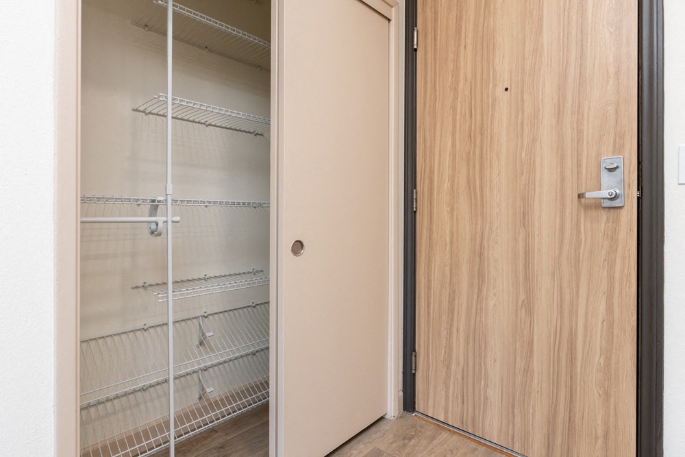 a door to a closet with empty shelves on the door
