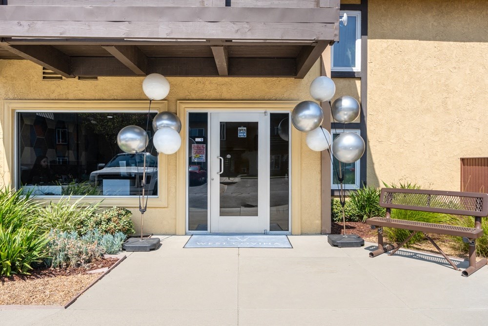 the front of a building with a door and a bench
