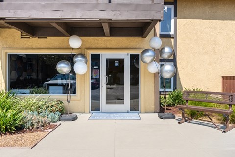 the front of a building with a door and a bench