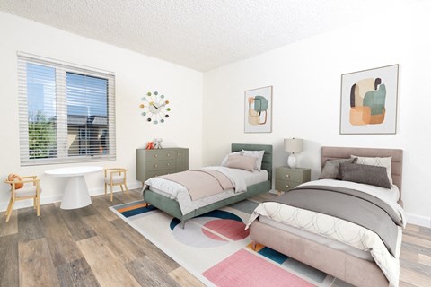 A bedroom with two beds and a table with chairs.