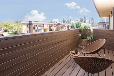 a deck with two chairs and a potted plant on it
