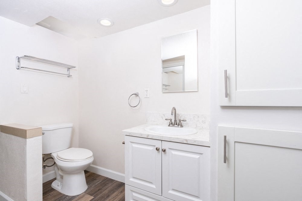 A white bathroom with a toilet, sink, and medicine cabinet.