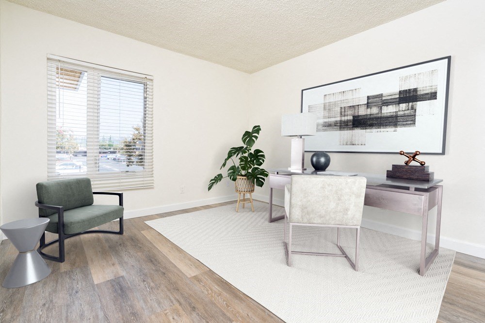 a living room with a white rug and a desk with a chair