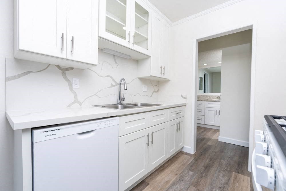 A white kitchen with a washer and dryer built in.
