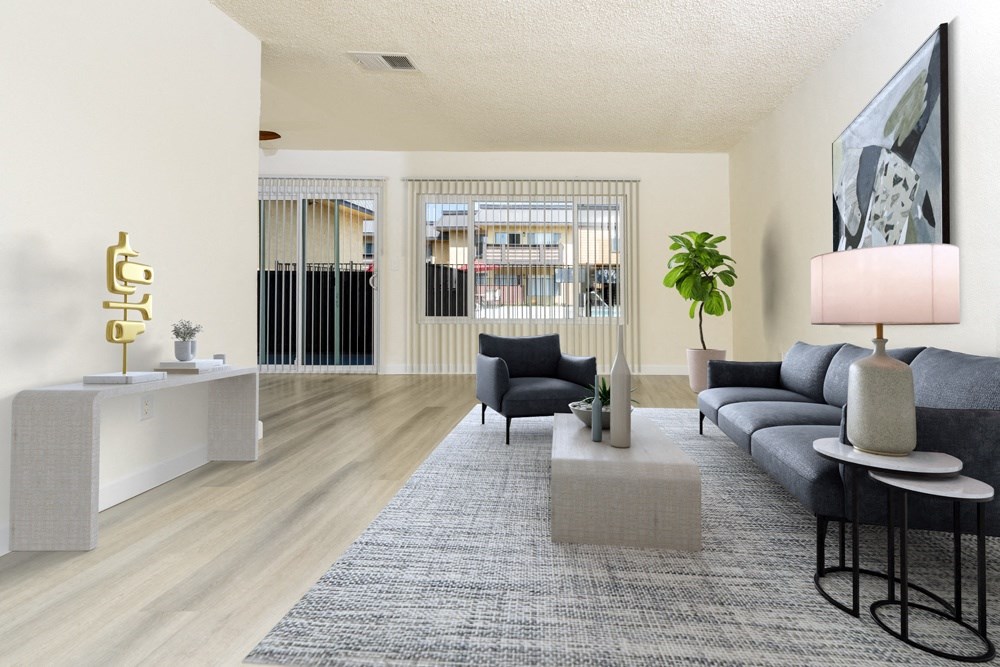 A living room with a grey sofa, a grey rug, a black chair, a white side table, and a gold sculpture.