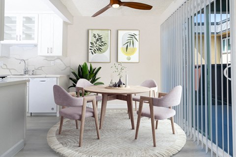 a dining room with a round table and pink chairs