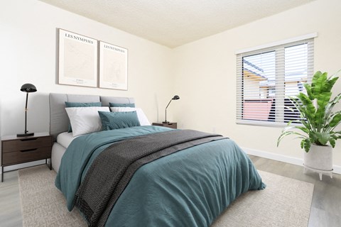 a bedroom with two windows and a bed with green sheets