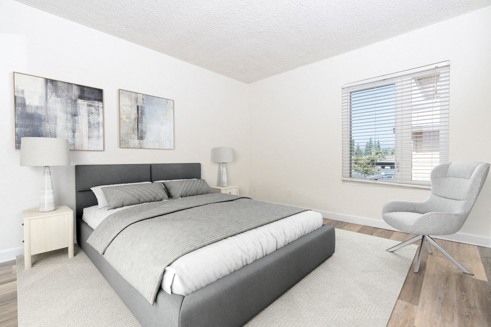 a bedroom with a bed and a chair and a window