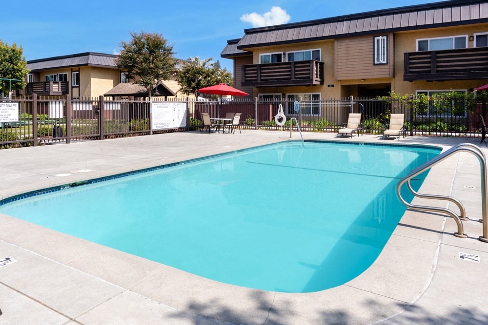 our resort style swimming pool is in front of our apartments with a fence