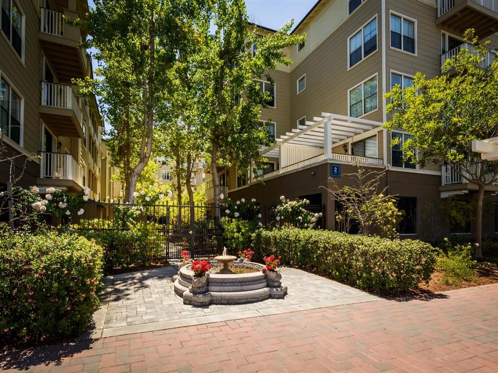 a courtyard with a fountain in front of an apartment building