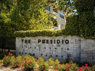 a stone wall with the presidio sign