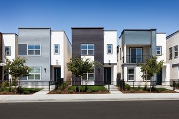 A row of modern houses with different shades of grey and white.