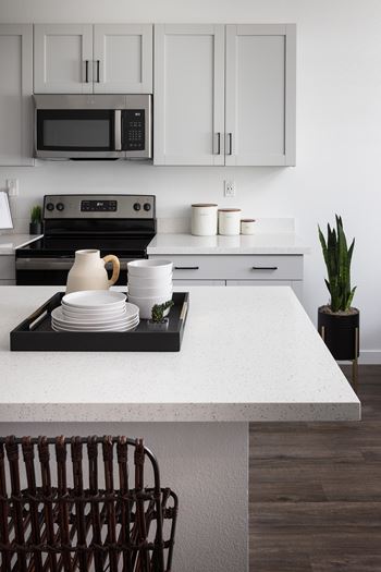 A modern kitchen with a black stove top and white countertop.