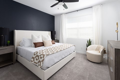 A bedroom with a large bed and a ceiling fan.