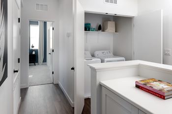 A white kitchen with a book on the counter.