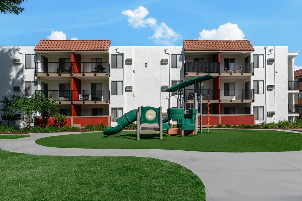 a playground in an apartment building with a large green slide