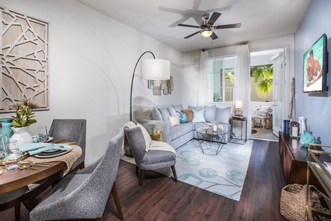 a living room with couches and a table and a ceiling fan