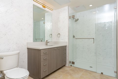 A bathroom with a toilet, sink, and shower.