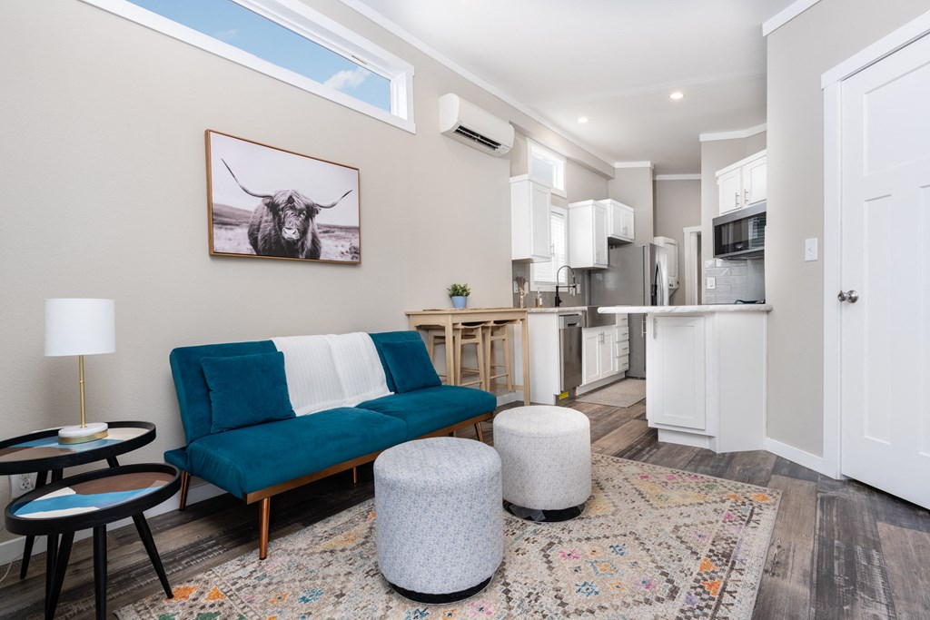 a living room with a blue couch and a kitchen in the background