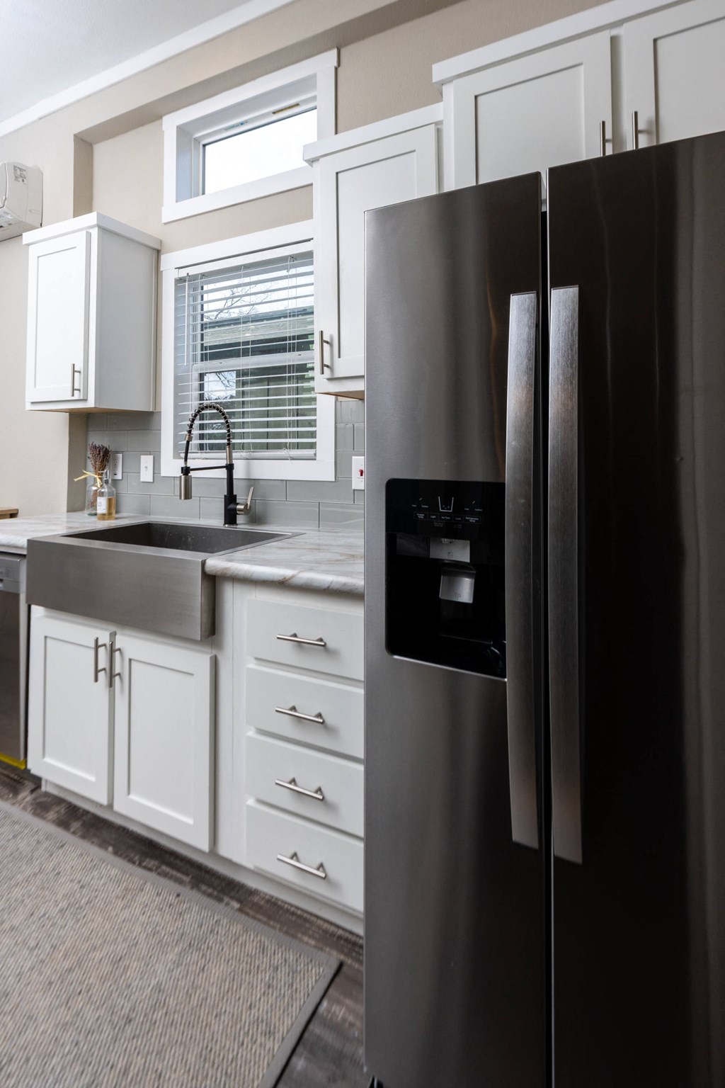 a kitchen with a stainless steel refrigerator and white cabinets