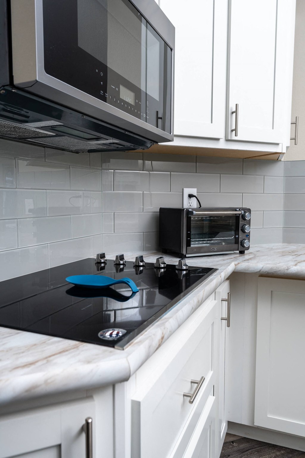 a kitchen with white cabinets and a stove and a microwave