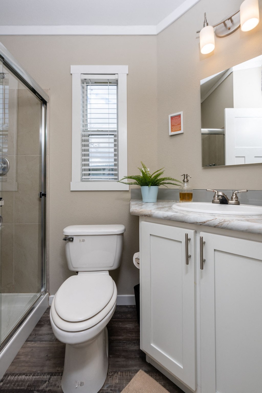 a bathroom with a toilet and a sink and a shower