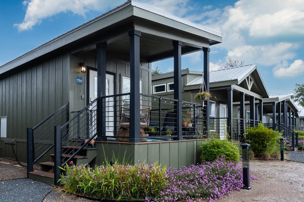 the front of a gray house with stairs and a porch