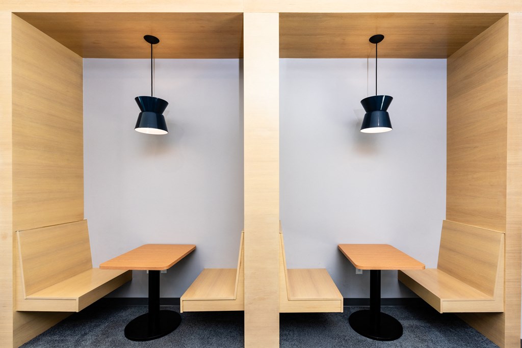 two tables and benches in a room with two black lamps