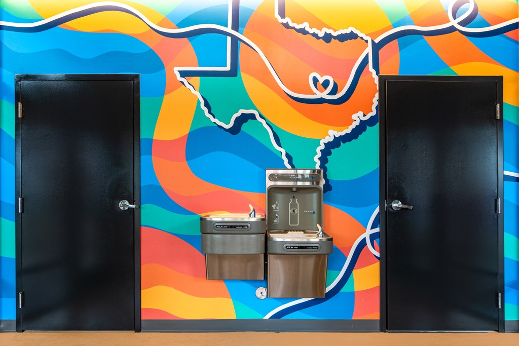 two doors in front of a wall with two trash cans between them