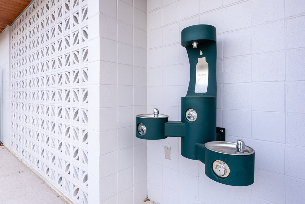 a urinal in a public restroom with two stainless steel urinals