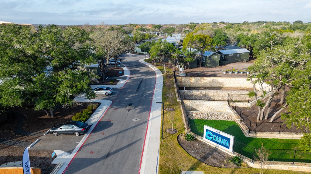 an aerial view of a street with cars and trees
