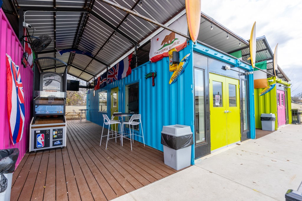 a building with a roof and a patio with tables and chairs