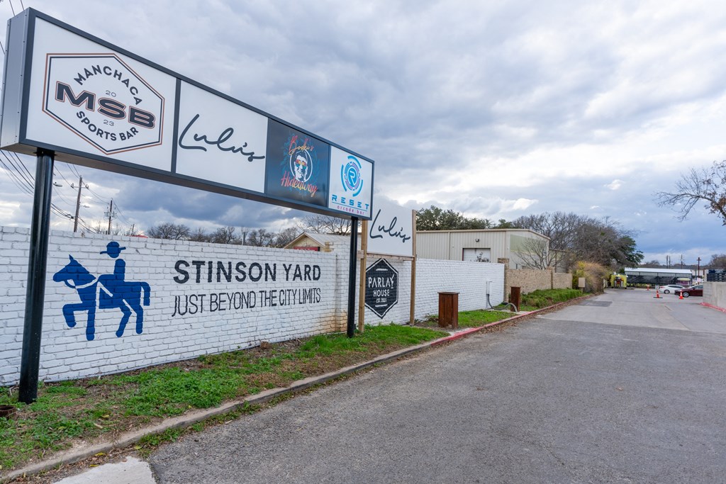 the sign in front of a white brick wall and a road