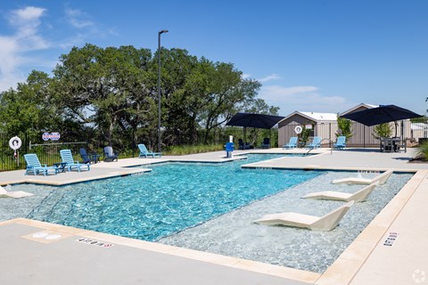 A large outdoor swimming pool with lounge chairs and umbrellas.