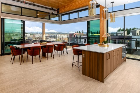 A modern kitchen with a long table and chairs.