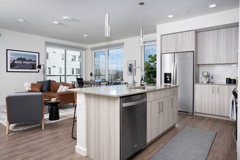 A modern kitchen with a large island and stainless steel appliances.